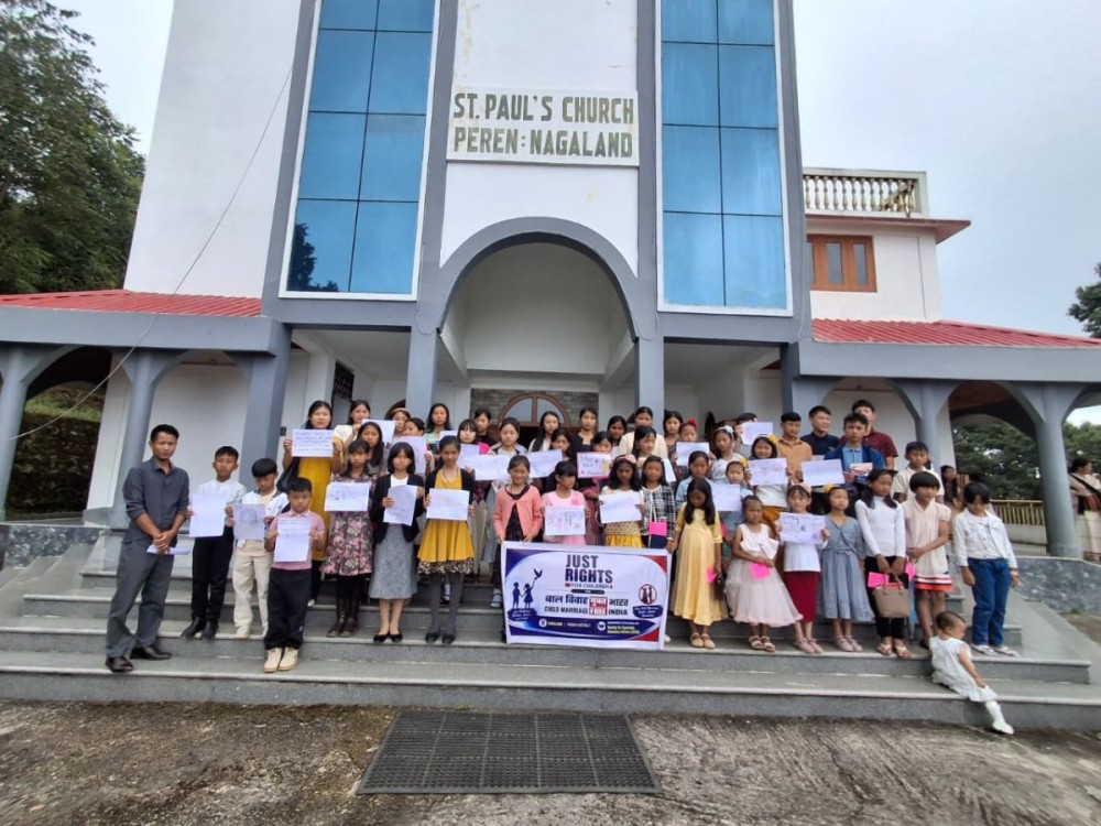 Members and children pose for a group photo holding awareness signs outside St. Paul's Church in Peren district, during a campaign by SEVA and Just Rights for Children (JRC) to strengthen child marriage prevention in Nagaland.